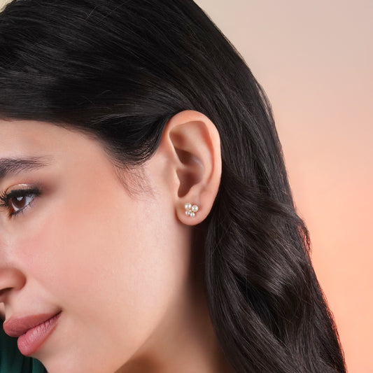 18k yellow gold pair of earrings decorated by a single zircon stone in the centre surrounded by different sizes of pearls