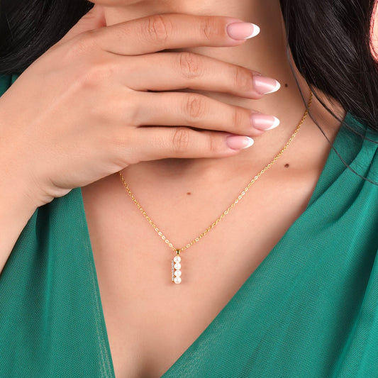 18k yellow gold necklace features 4 pearls aligning with zircon stones