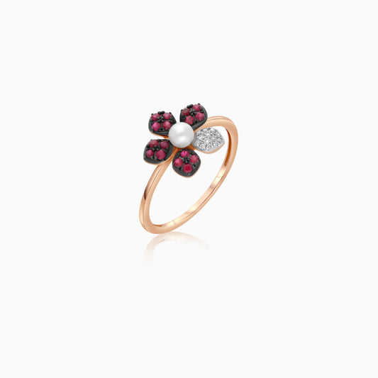 18k rose gold ring with a flower shape on the top decorated with natural diamonds, ruby stones and a single pearl in the center
